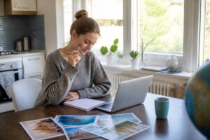 Vakantie vergelijken met laptop en notitieboekje aan een keukentafel